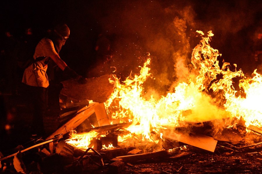 Manifestante alimenta fogueira em protesto no Chile, em 2019